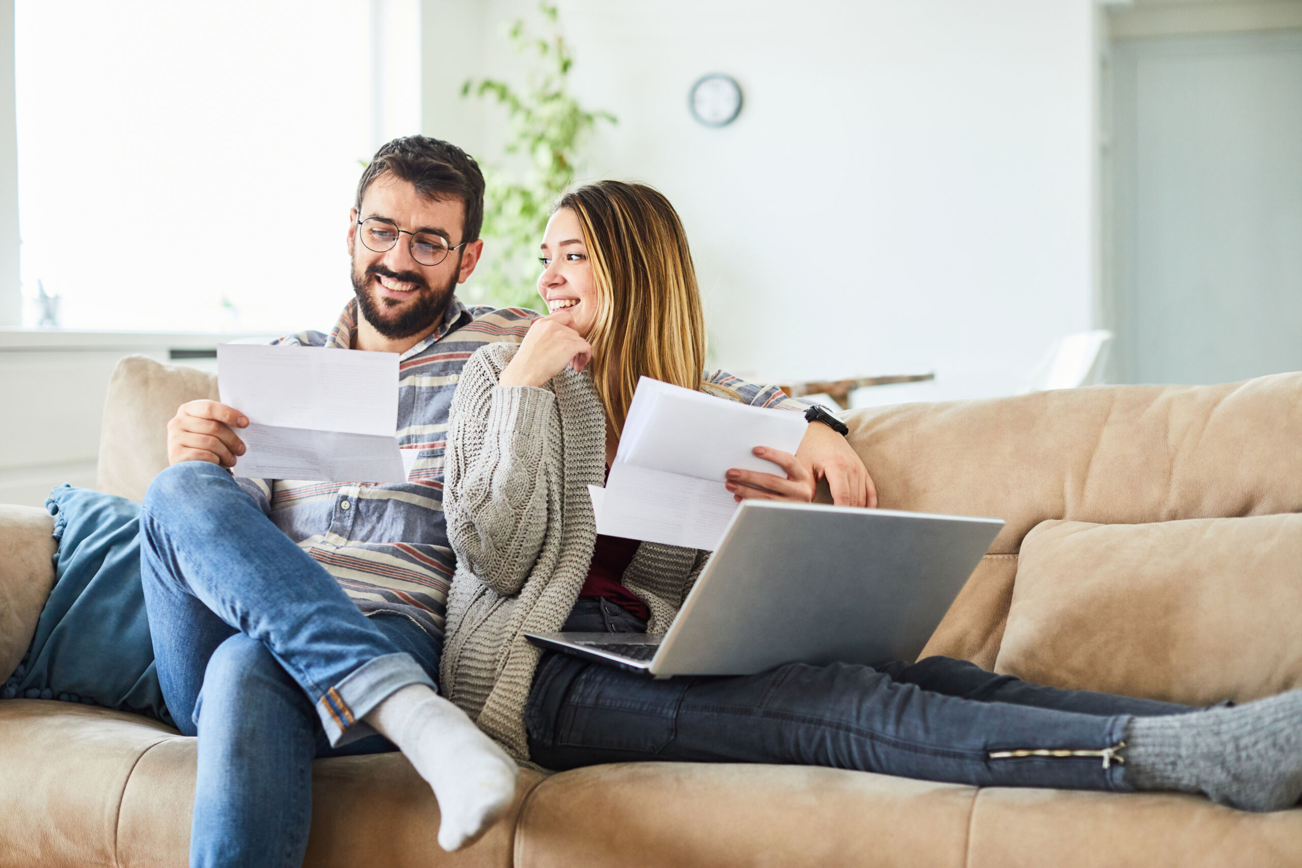 An image of a married couple reviewing their savings together and smiling. Solar Financing or Leasing?