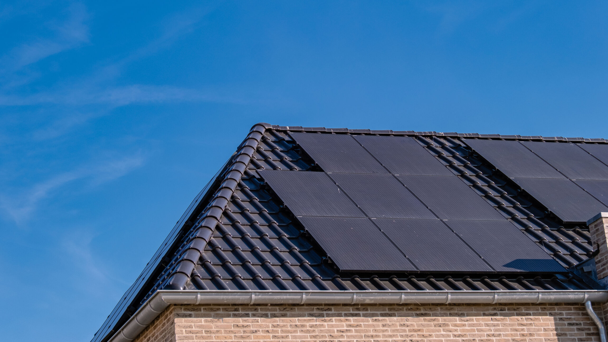 A house with an immaculate metal roof, undamaged by solar panels installed on top of it. 