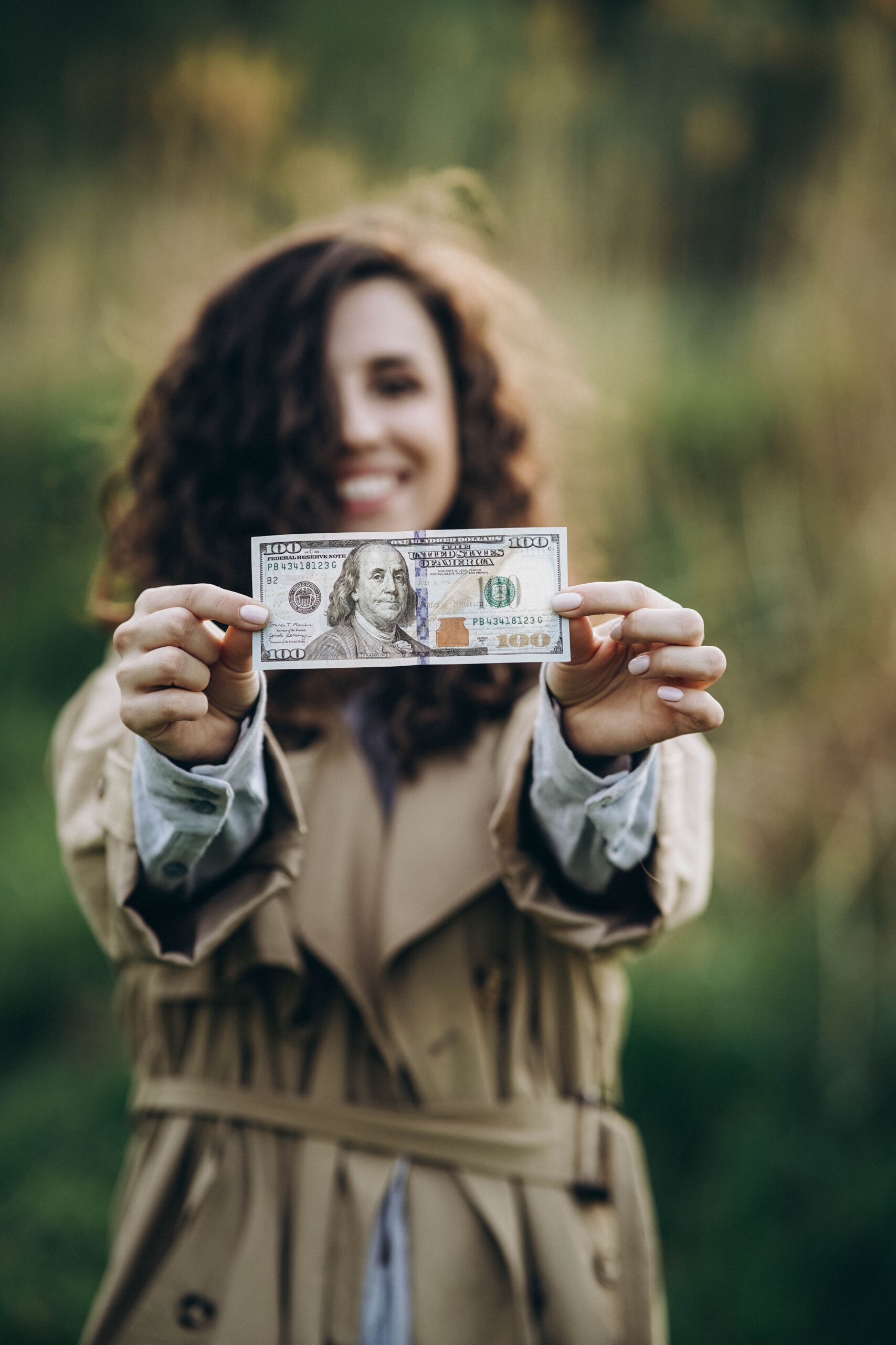 An image of a woman holding up the money she saved on her electric bill. How the solar tax credit works. 